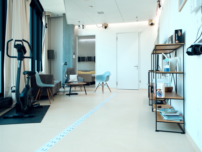 Wohnzimmer mit Möbeln und Hometrainer und mit Messband am Boden